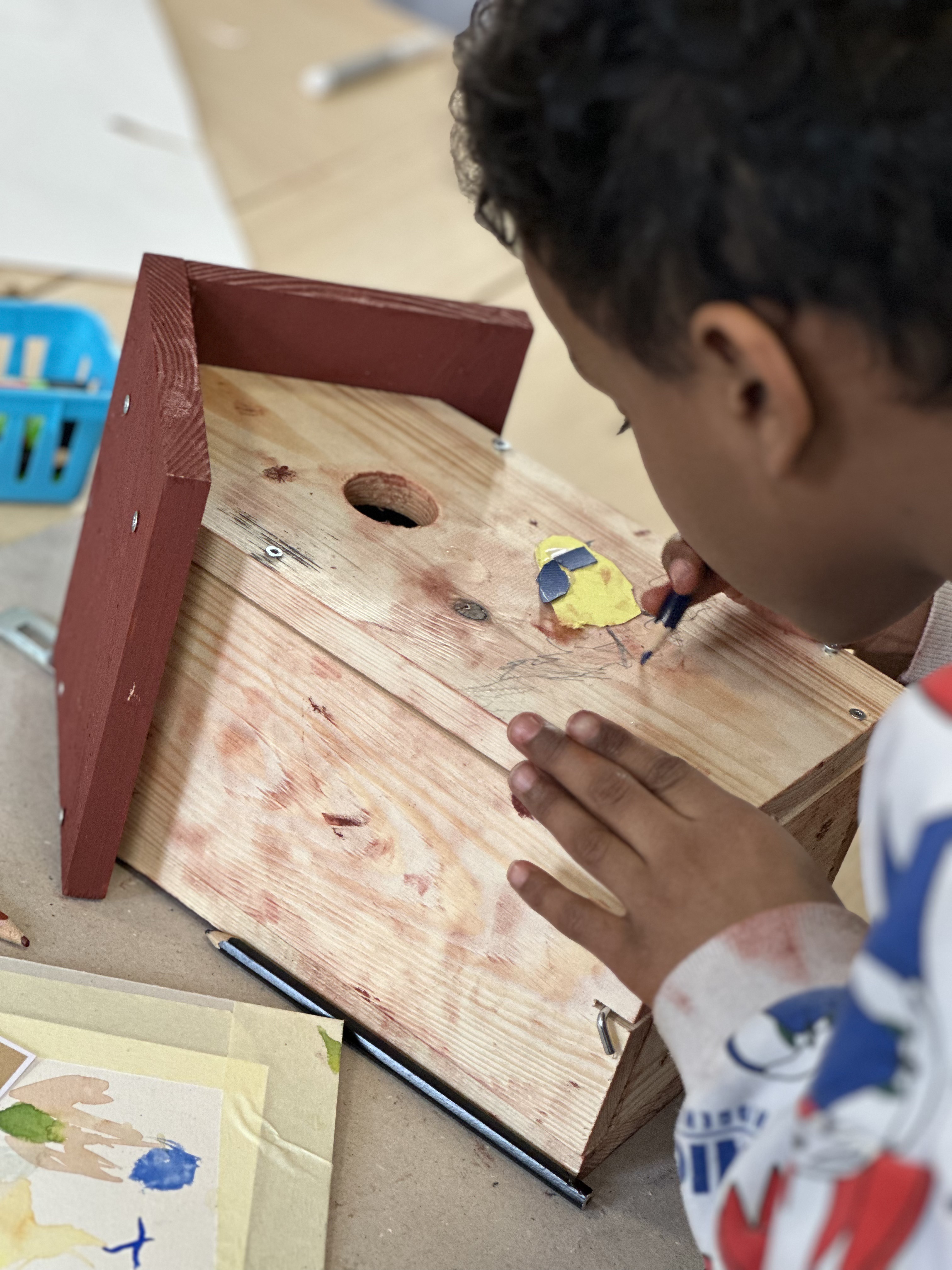 Main d'enfant dessinant sur son nichoir lors d'un atelier d'art au CSM Mouscron