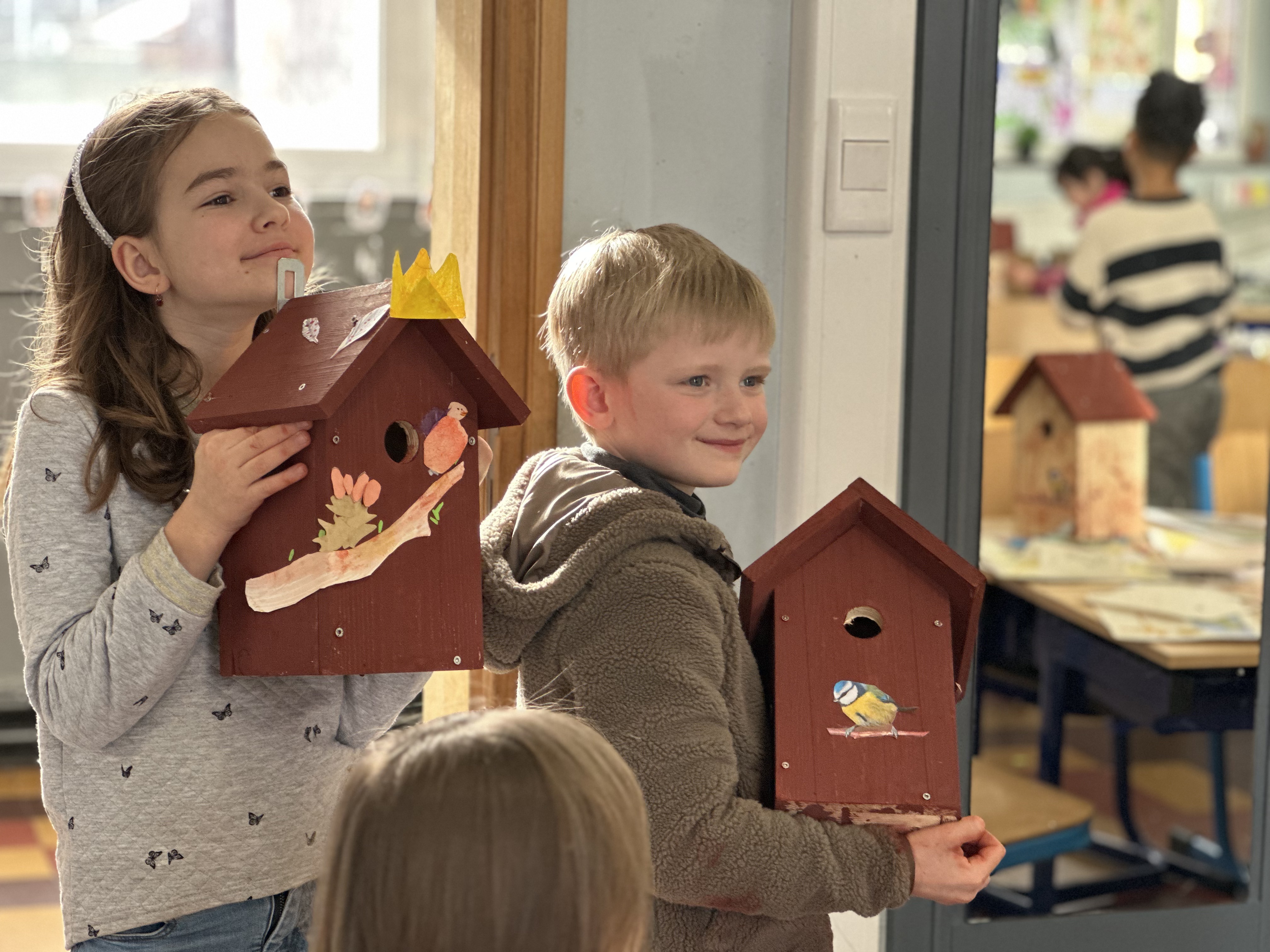 Deux élèves de primaire du CSM fiers de leur nichoir à mésanges fabriqué en classe