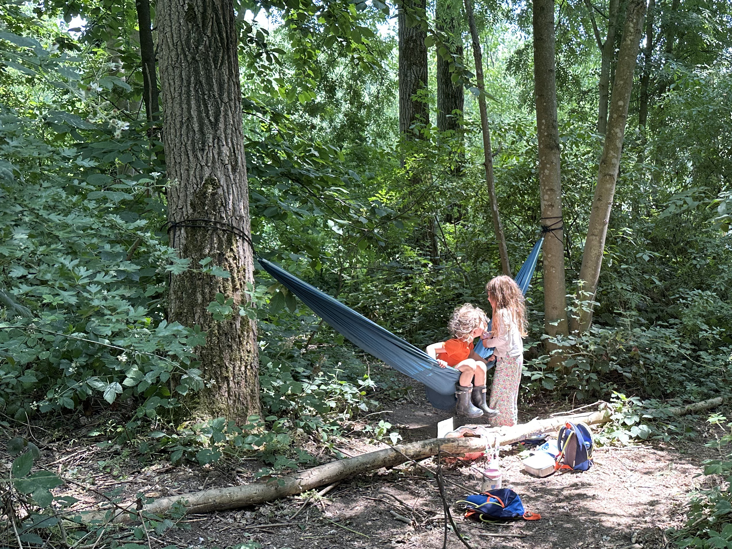 Enfants jouant librement dans un hamac en forêt