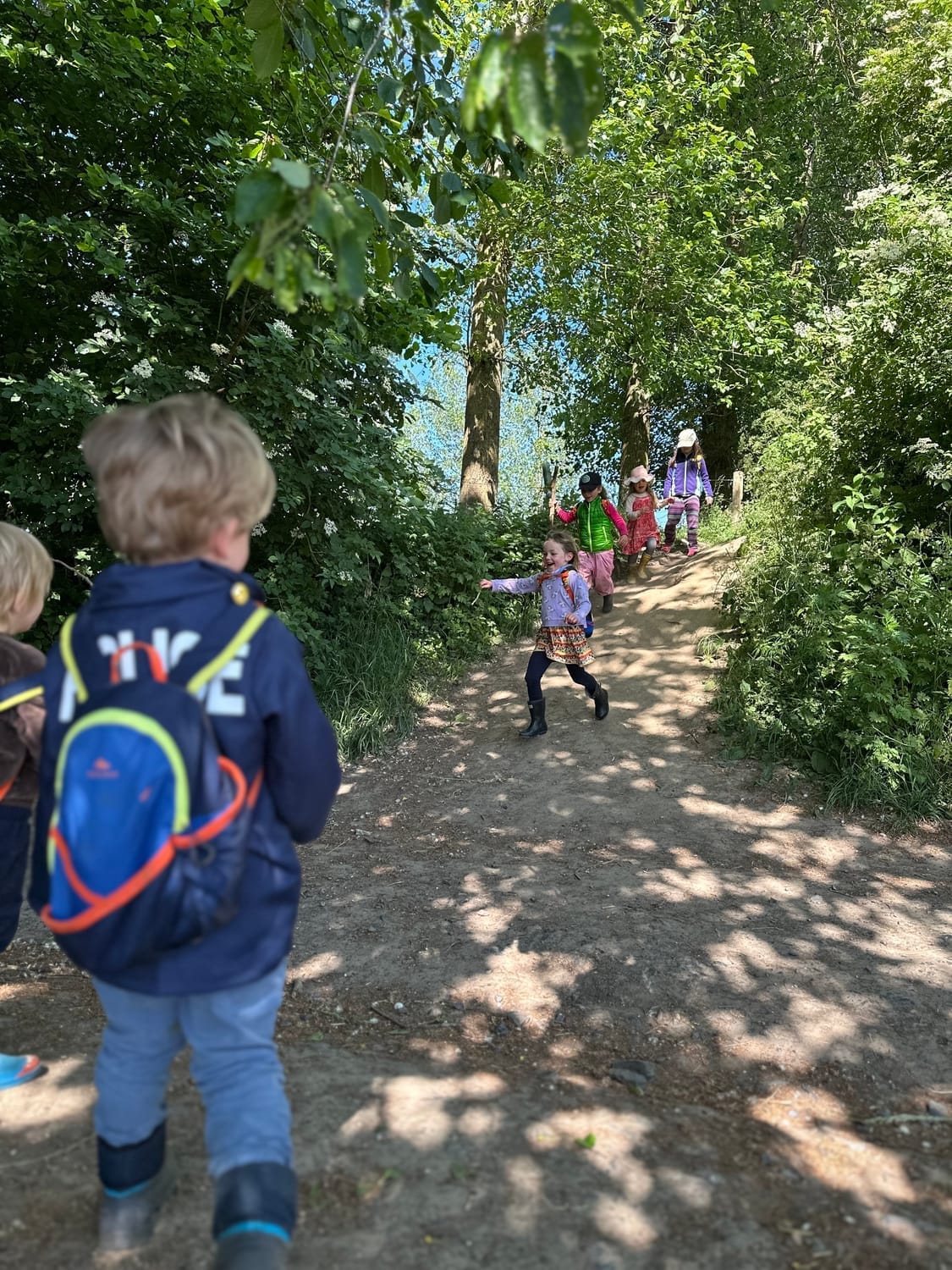 Enfants courant sur la grande pente en direction de la forêt