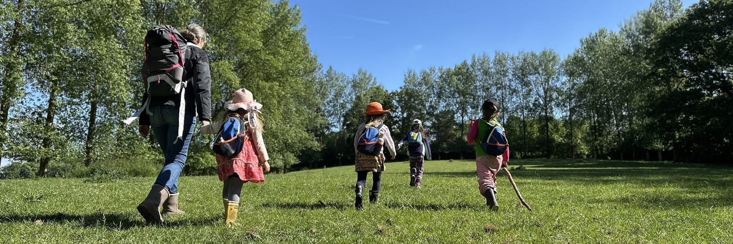 Cécile et les enfants en route vers la forêt à travers la campagne