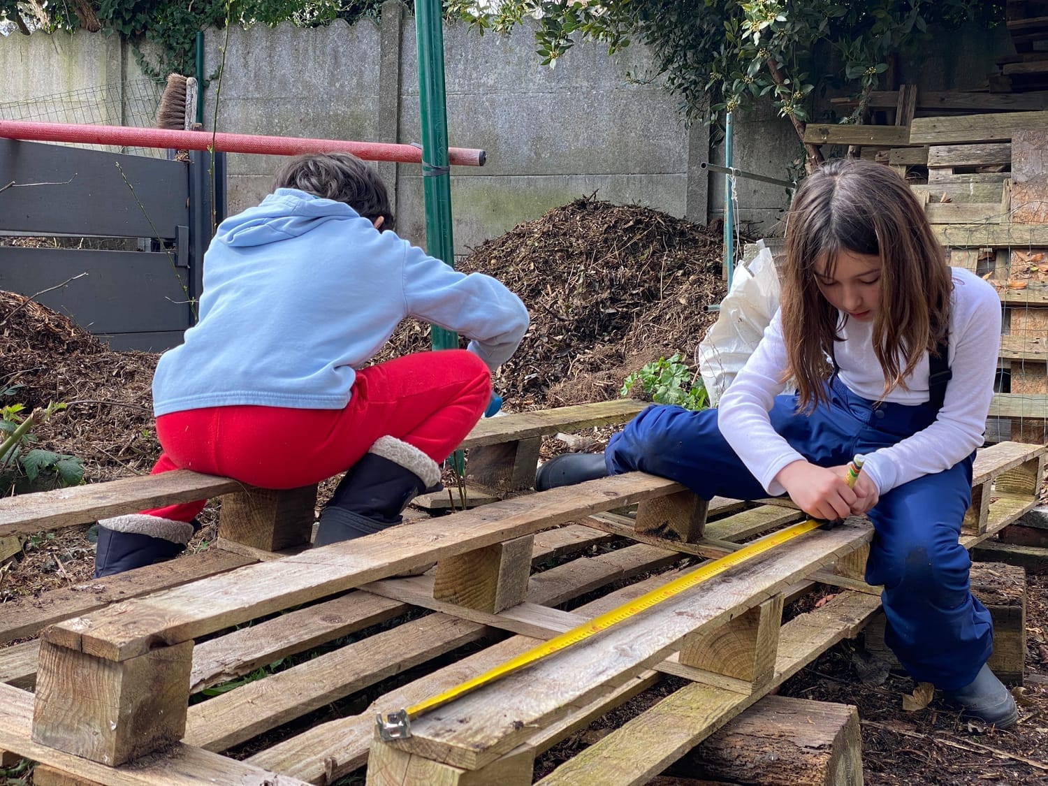 Enfant mesurant et traçant les repères sur une palette